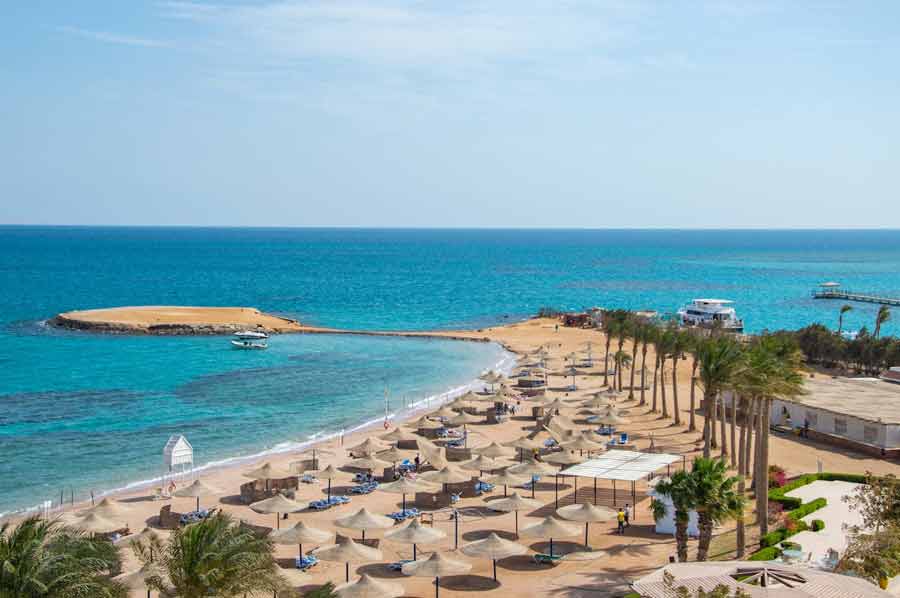 Plage de Paradise Beach sur l’île de Giftun près d’Hurghada, bordée de parasols et de palmiers face à la mer Rouge