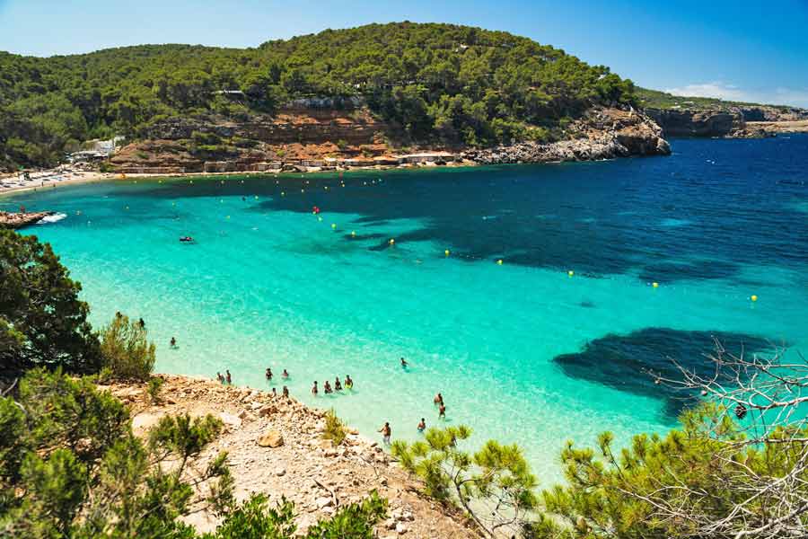plage turquoise et crique ensoleillée à Sant Antoni, proche d'une location  de villa gérée par Le Collectionist à Ibiza