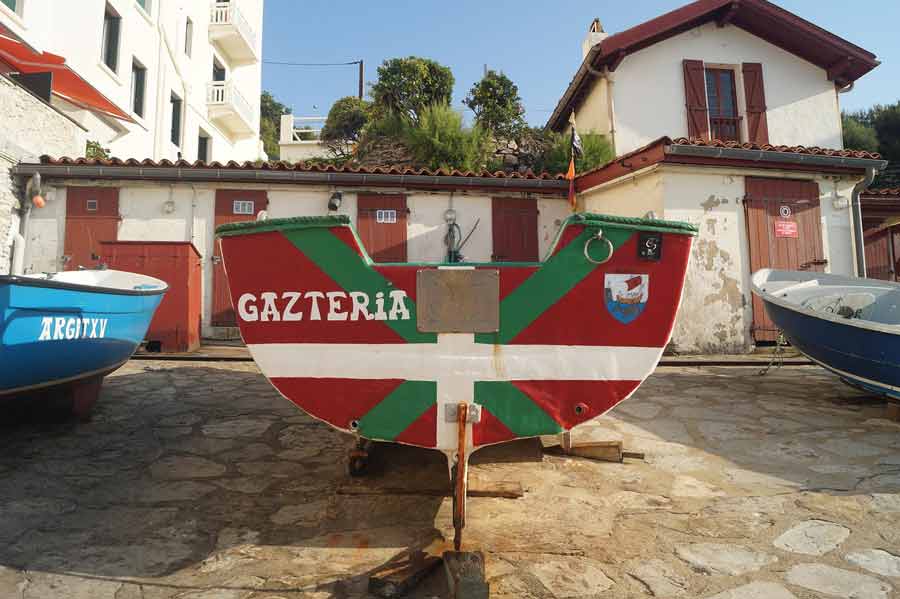 Barque traditionnelle aux couleurs du Pays basque sur le littoral, symbole de l’identité maritime locale mise en valeur par Merkatu blog