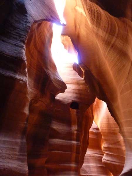 Faisceau de lumière pénétrant Upper Antelope Canyon, parois de grès sculptées aux teintes orangées et rouges