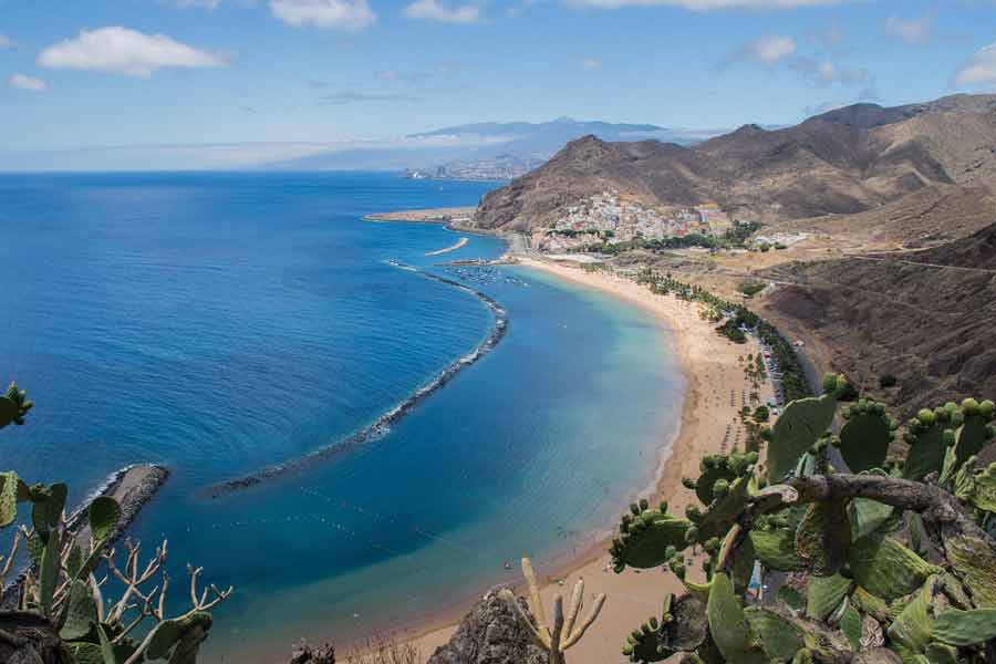tui-7 Vue panoramique de Santa Cruz de Tenerife aux Canaries, plage dorée et océan Atlantique bordé de montagnes volcaniques