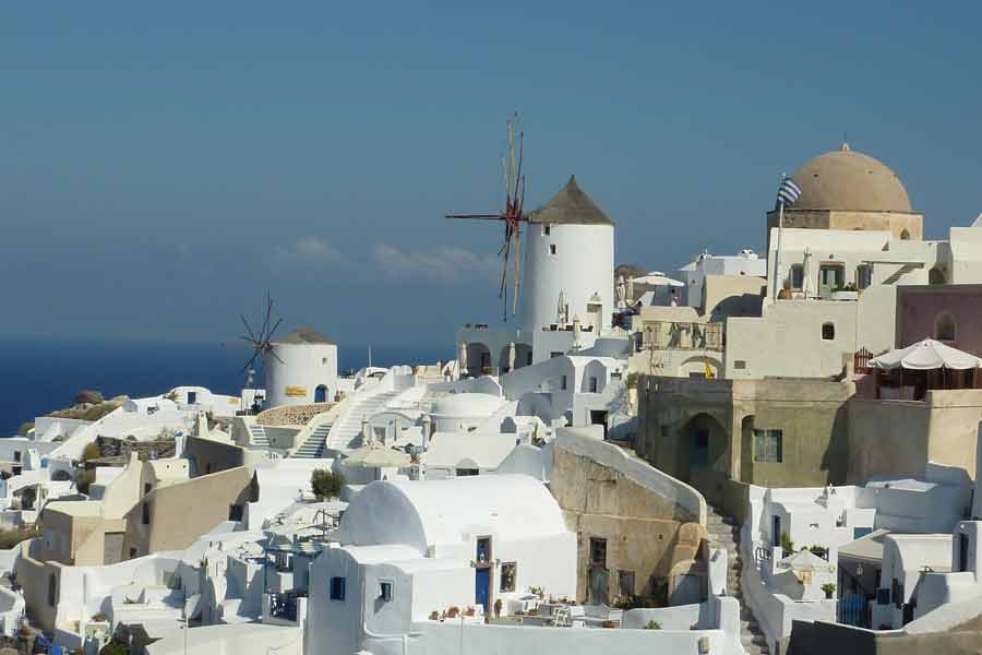 Village d’Oia à Santorin en Grèce avec maisons blanches et moulins face à la mer Égée