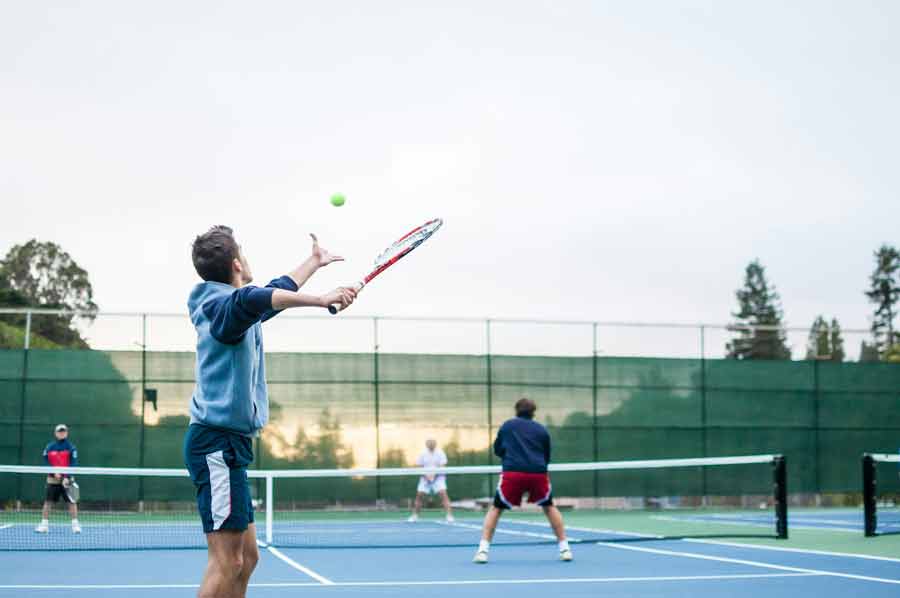 Joueurs de tennis en train de servir et échanger sur un court pendant des vacances sportives avec Fram