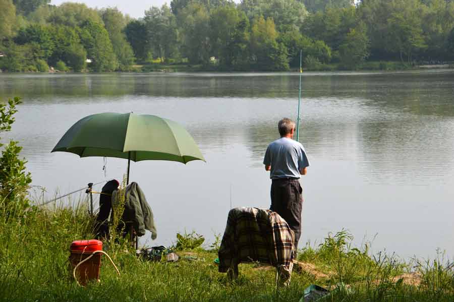 Homme qui pêche à proximité du village Iris Vacance sur le lac de Sèchemailles en Corrèze