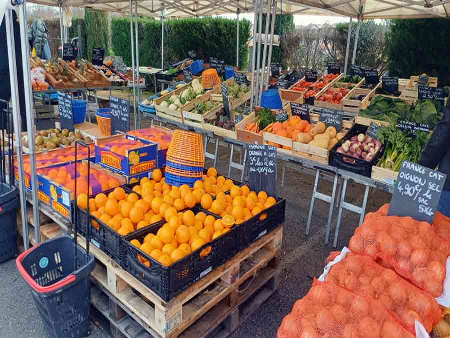 Marché local en Corrèze avec étals de fruits et légumes frais, ambiance authentique et produits du terroir près du lac de Sèchemailles
