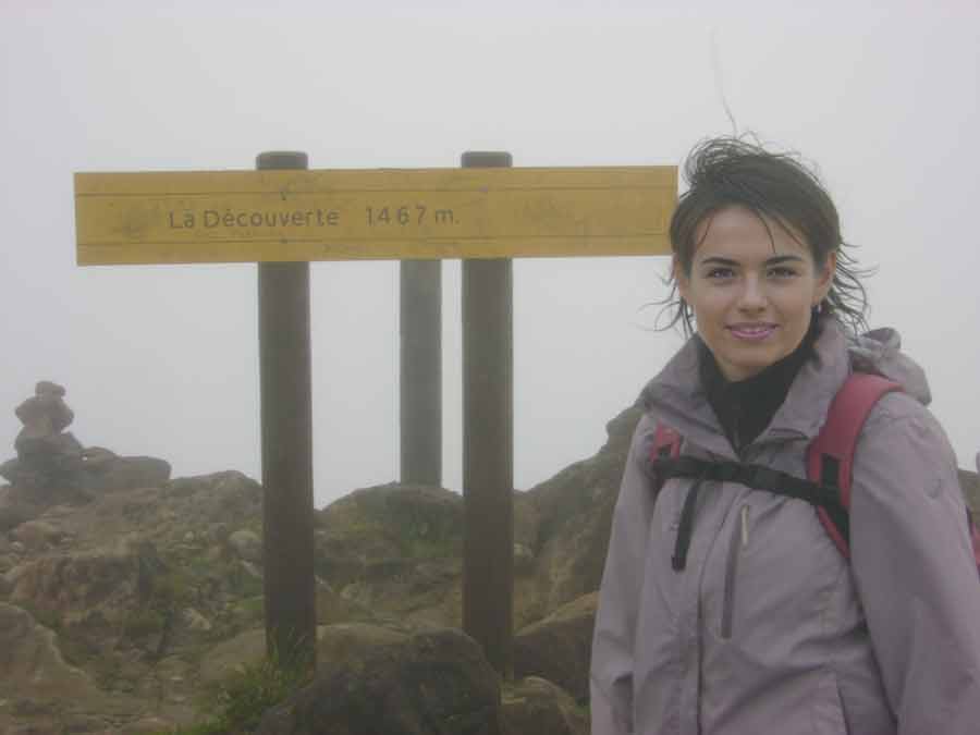 randonnée au sommet de la Soufrière en Guadeloupe au mois d'avril avec randonneuse devant le panneau La Découverte dans la brume