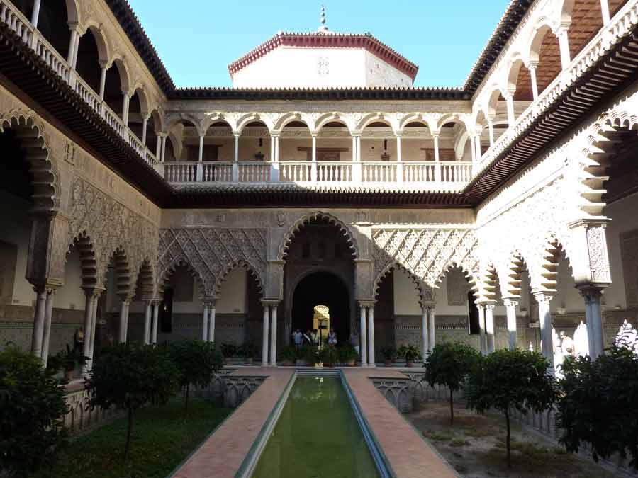 Patio intérieur de l'alcazar de Séville avec arches mauresques et bassin central en Andalousie (Espagne)