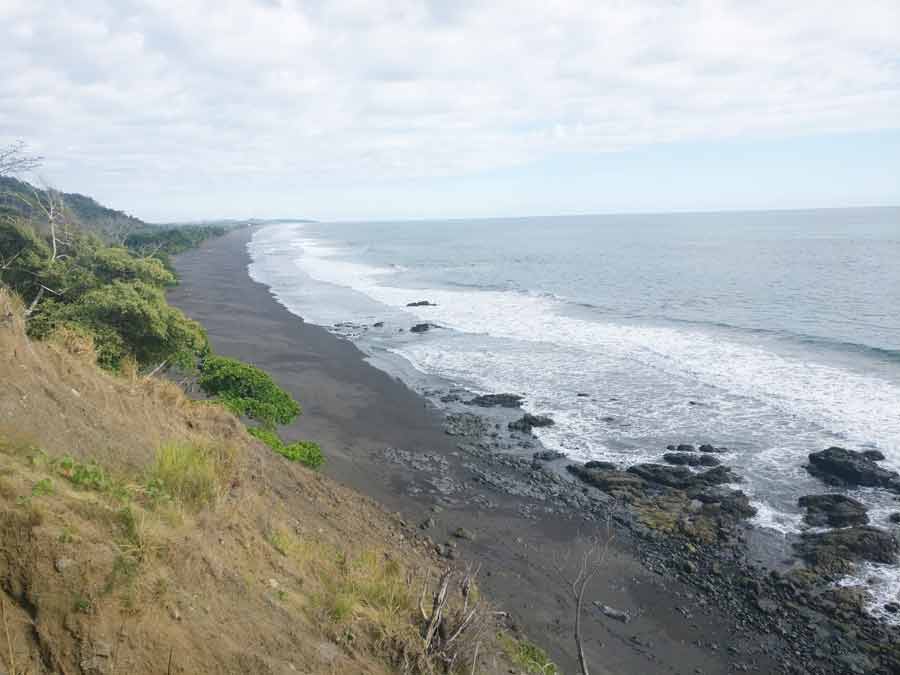 plage du parc Manuel Antonio au Costa Rica en avril avec sable sombre, océan et jungle tropicale
