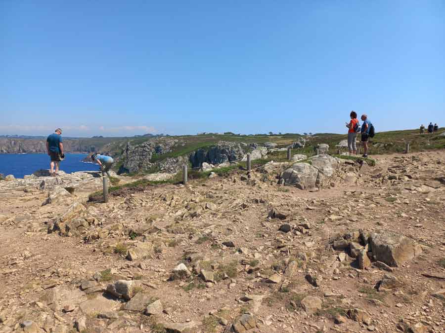Promeneurs observant les falaises de la pointe du Van sur le sentier côtier du Cap-Sizun