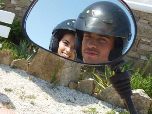 Reflet complice d'un couple de voyageurs casqués dans le rétroviseur de leur quad à Mykonos