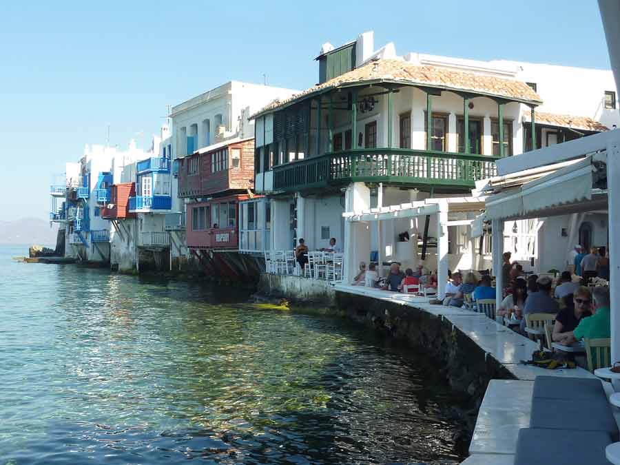 Les maisons colorées aux balcons en bois de Little Venice à Mykonos, construites en surplomb de la mer Égée, avec leurs terrasses de restaurants animées au bord de l'eau