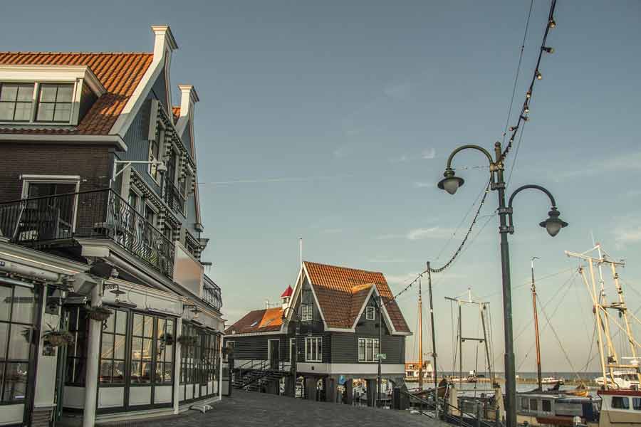Maisons traditionnelles en bois et port de Volendam près d’Amsterdam au coucher du soleil