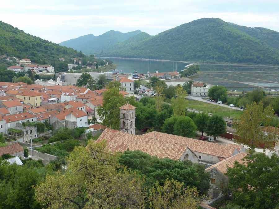 Vue sur le village de Ston en Croatie avec l’église, les toits en tuiles et la baie en arrière-plan