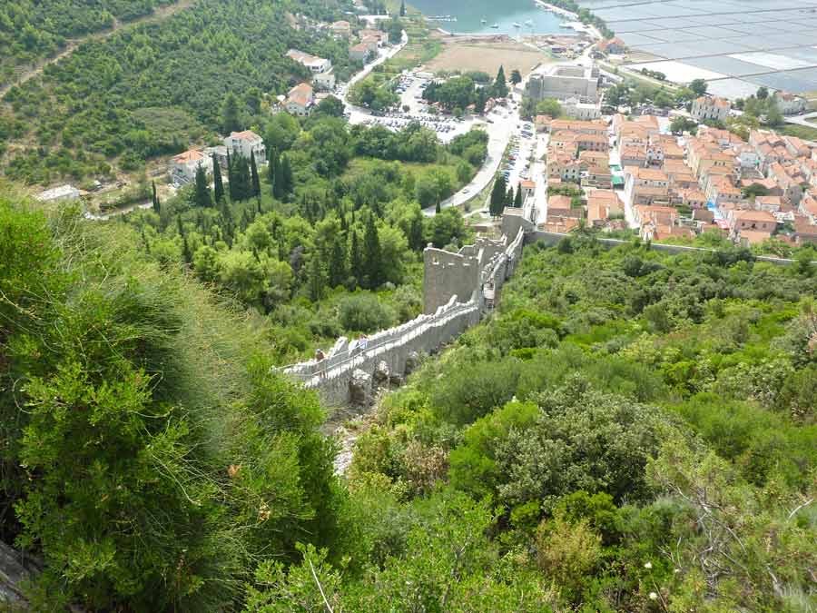 Remparts de Ston en Croatie descendant la colline avec vue sur la végétation et la baie de Mali Ston