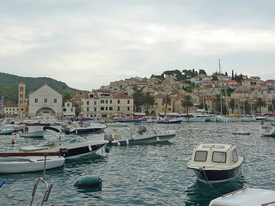 Vue sur la vieille ville de Hvar depuis la mer, avec ses toits en tuiles orangées et l'église Saint-François au bord du port
