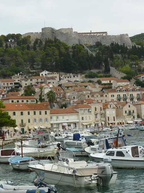 Le port de Hvar avec ses bateaux de pêche et la forteresse Fortica dominant la vieille ville, Croatie