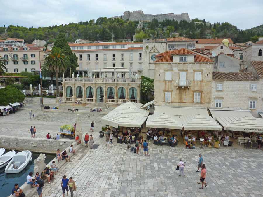Place Saint-Étienne de Hvar avec ses terrasses animées, ses palais vénitiens en pierre et la forteresse Fortica en arrière-plan