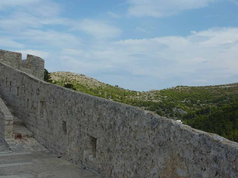Les remparts en pierre de la forteresse Fortica de Hvar avec vue sur les collines karstiques de l'île, Croatie