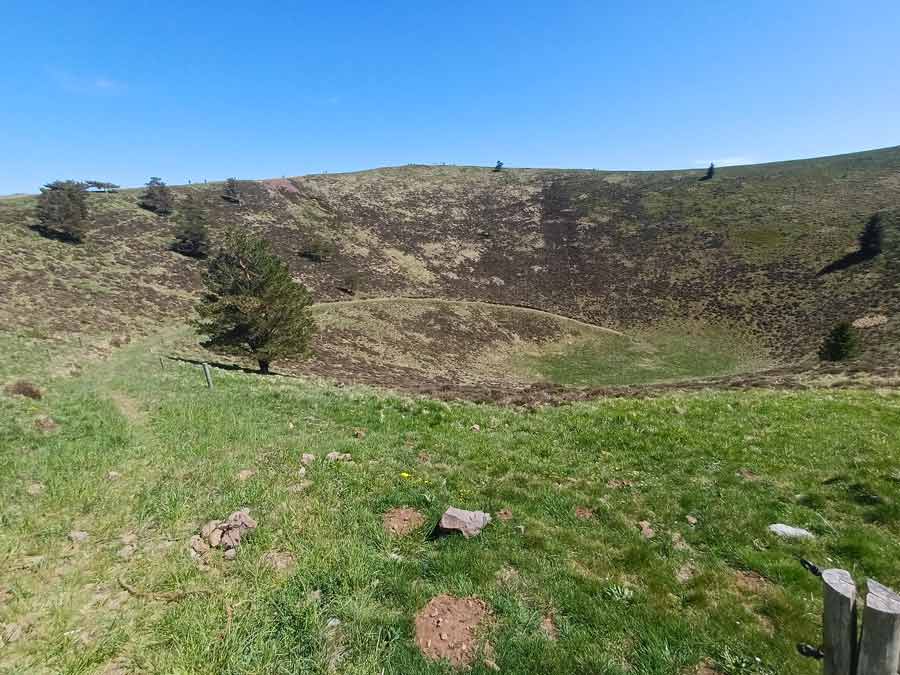 Cratère du puy Pariou vu depuis la lèvre supérieure, révélant ses parois de scories volcaniques sombres et sa végétation rase caractéristique, volcan strombolien de 90 mètres de profondeur classé à l'UNESCO dans la Chaîne des Puys en Auvergne