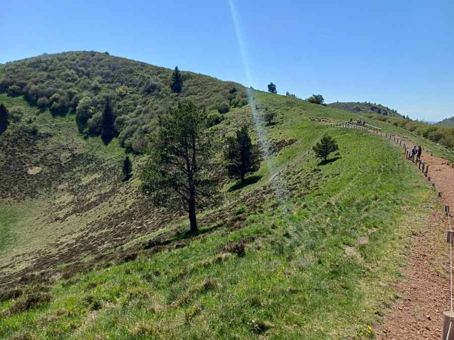Sentier balisé longeant la crête du puy Pariou avec randonneurs en file, Chaîne des Puys en Auvergne