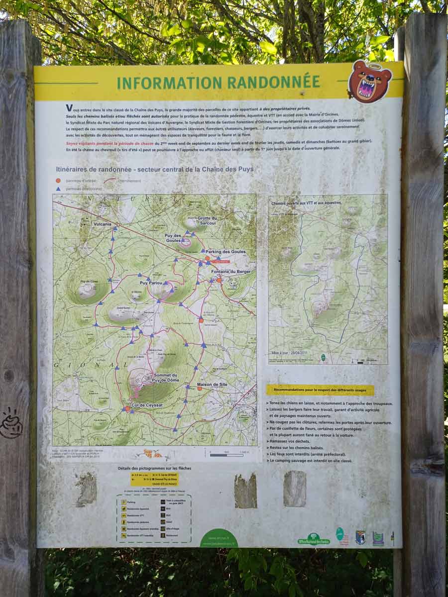 Panneau d'information sur les randonnées dans la Chaîne des Puys, affichant une carte détaillée des itinéraires pédestres et équestres du secteur central avec le puy Pariou, le parking des Goules et le puy de Dôme, accompagné des recommandations de respect du site classé UNESCO en Auvergne