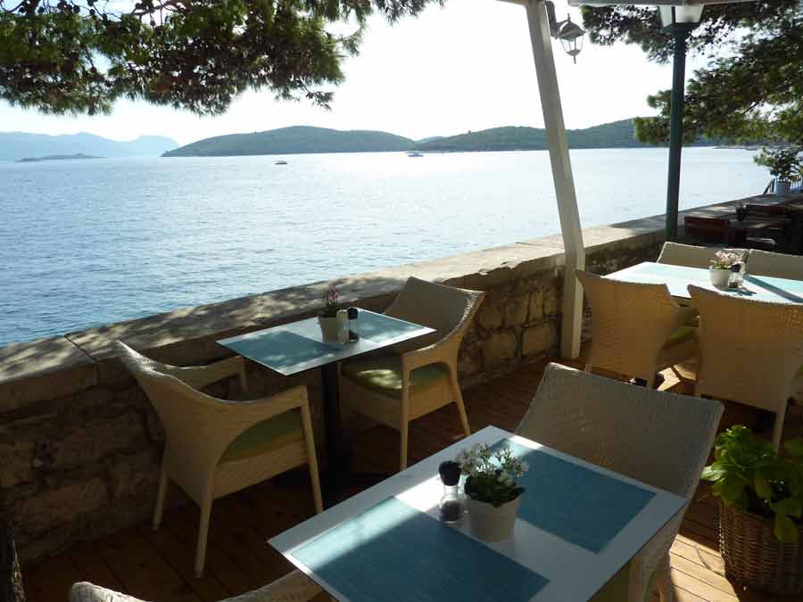 Vue sur la mer et les îlots depuis la terrasse du bar Massimo à Korčula, avec ses tables face au large