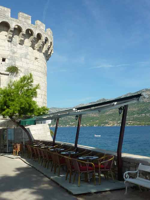 Terrasse du Cocktail Bar Massimo perchée au pied des remparts de la vieille ville de Korčula, avec vue sur le canal de Pelješac
