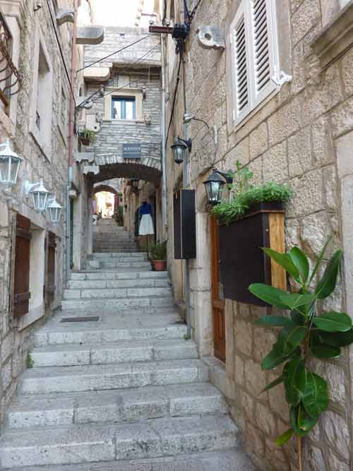 Escaliers et passage voûté dans les ruelles de la vieille ville de Korčula, avec ses maisons en pierre et ses lanternes traditionnelles
