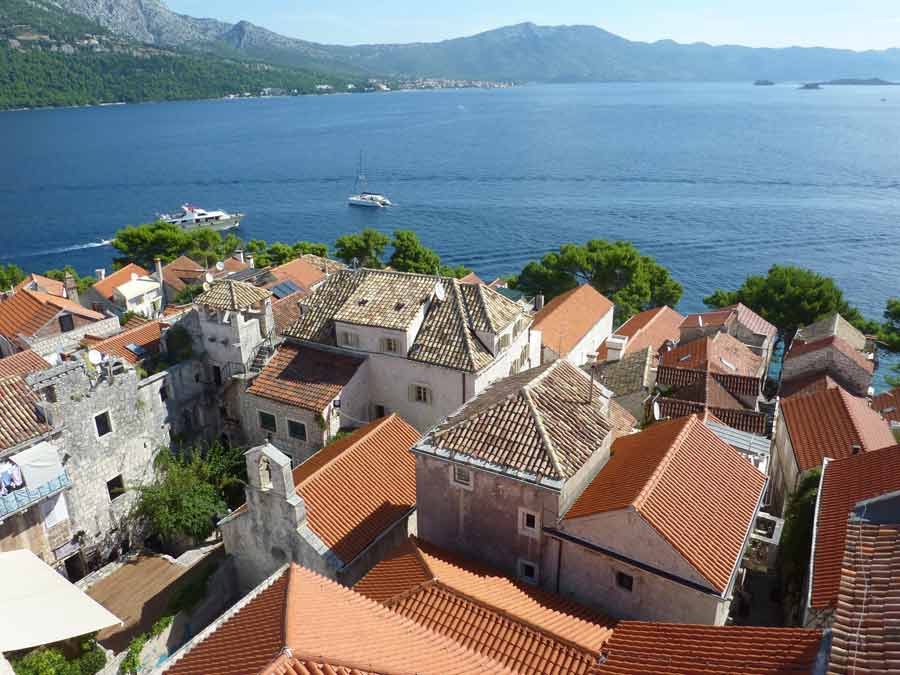Vue sur les toits de la vieille ville de Korčula et le canal de Pelješac depuis le clocher de la cathédrale Saint-Marc, avec la presqu'île en arrière-plan