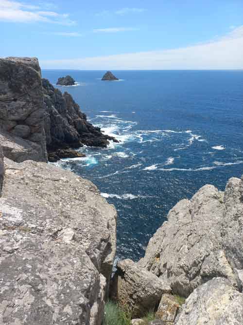 Vue plongeante depuis les falaises de Pen Hir sur les rochers battus par les vagues et deux des Tas de Pois au large, presqu'île de Crozon, Bretagne