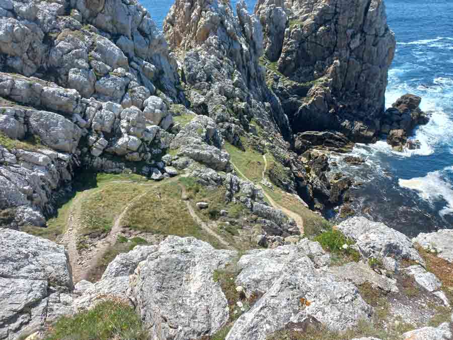 Sentier d'escalade serpentant entre les parois rocheuses verticales de la pointe de Pen Hir, illustrant le potentiel du site pour la grimpe