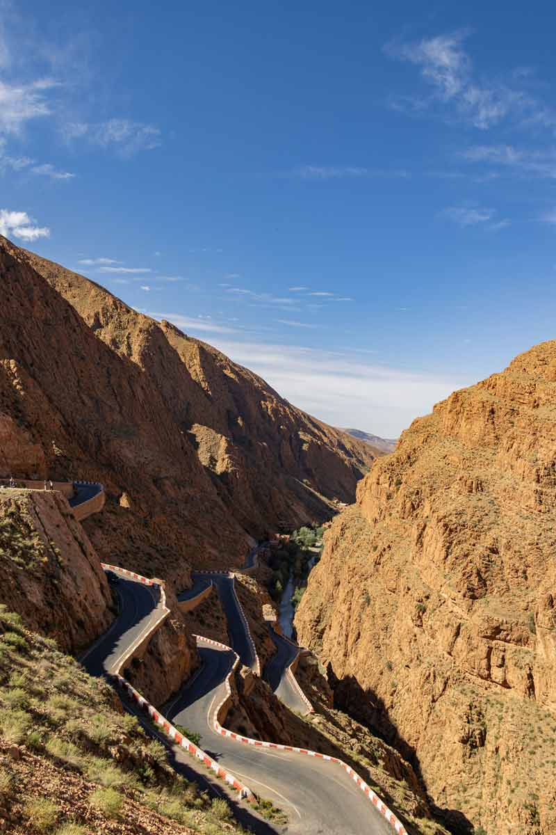 road-trip-maroc-2 Route en lacets des gorges du Dadès bordée de falaises ocre, étape incontournable du road trip entre Marrakech et le désert